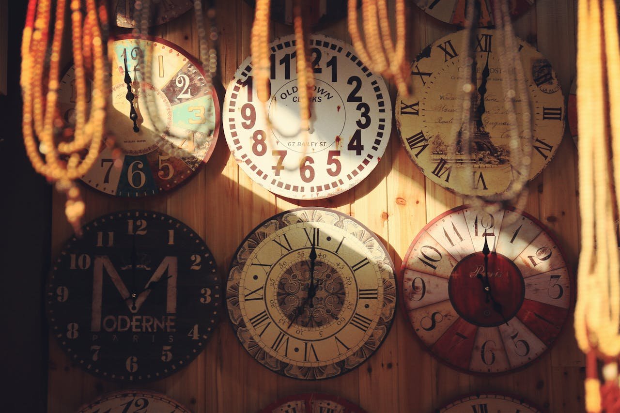 Collection of vintage wall clocks with unique designs on a wooden wall, creating a rustic decor vibe.